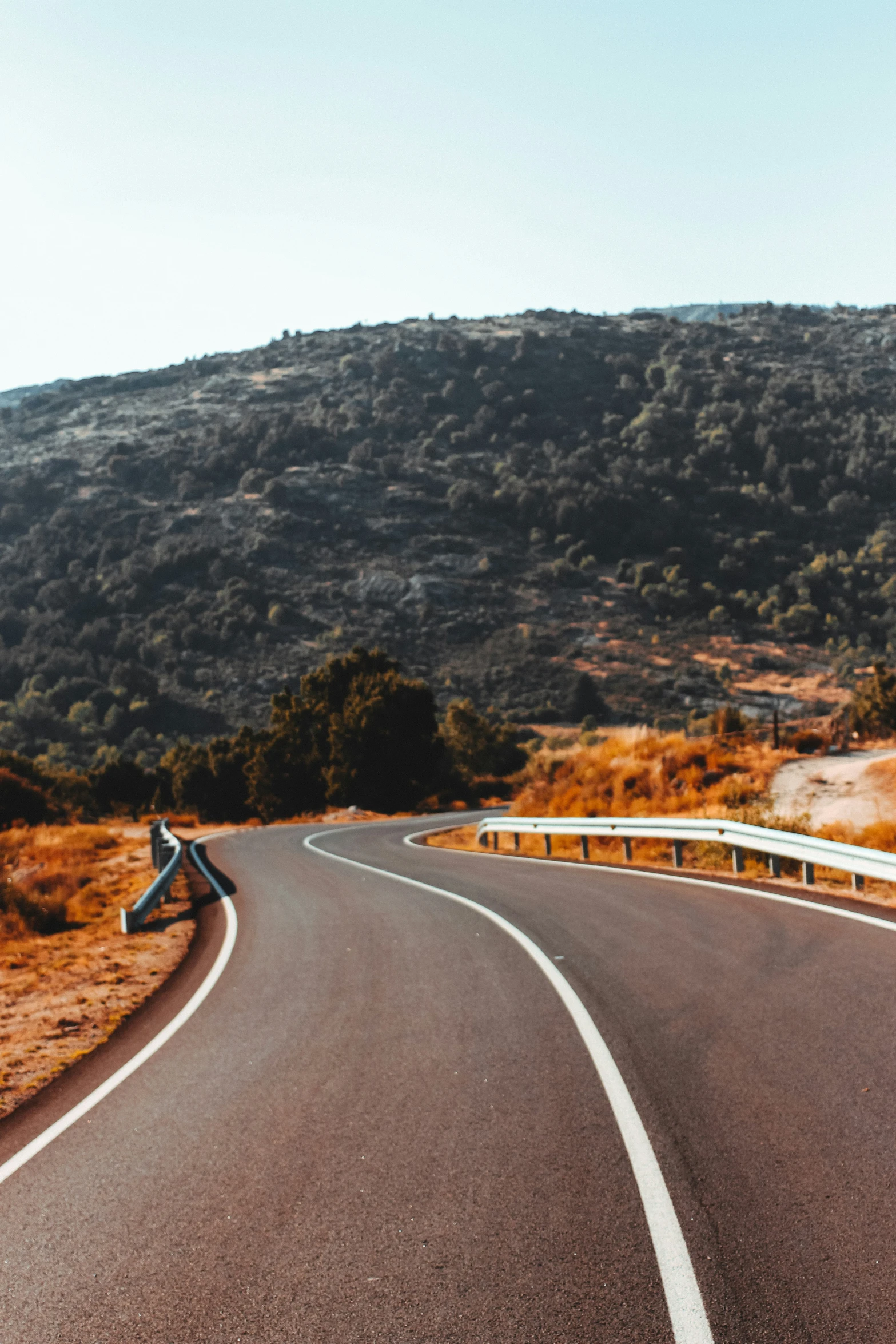 an empty road with a few motorcycles driving on it