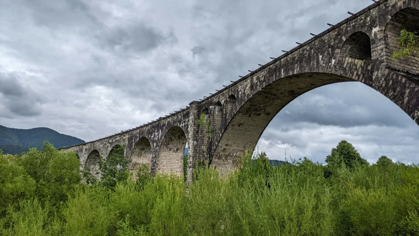 an old stone bridge crosses the river