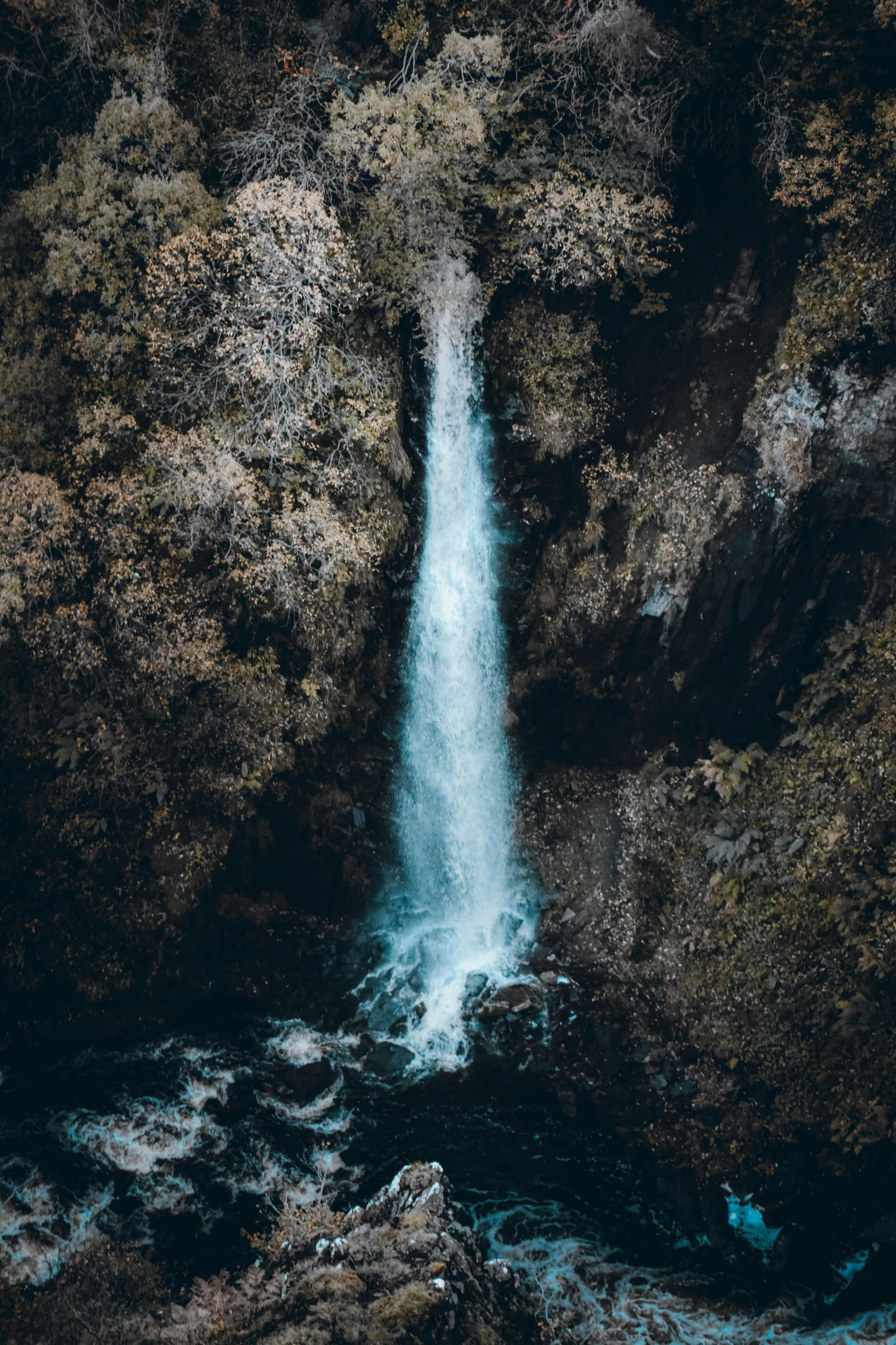 an overhead view of a waterfall flowing out of the rocks