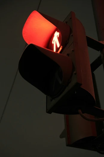 the light is red and shows the pedestrian symbol