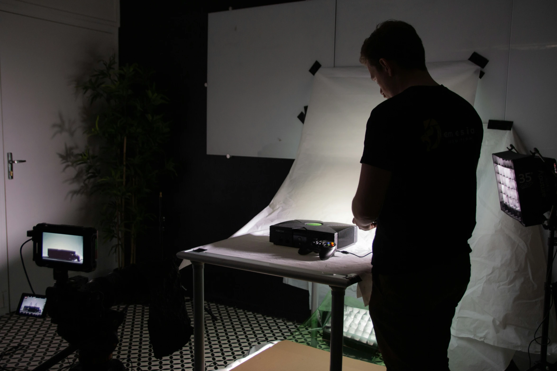 a man in dark po studio setting a laptop