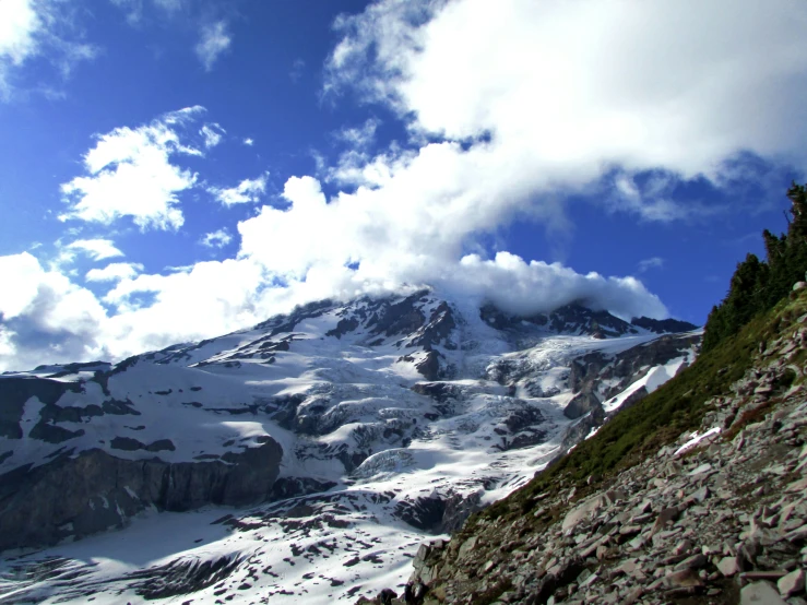 a mountain covered in snow with rocks and grass