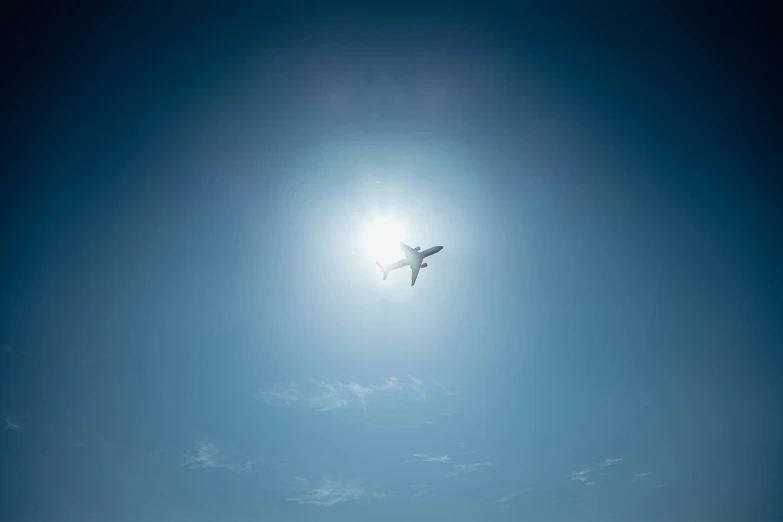 the sun is shining on an airplane flying high in the sky