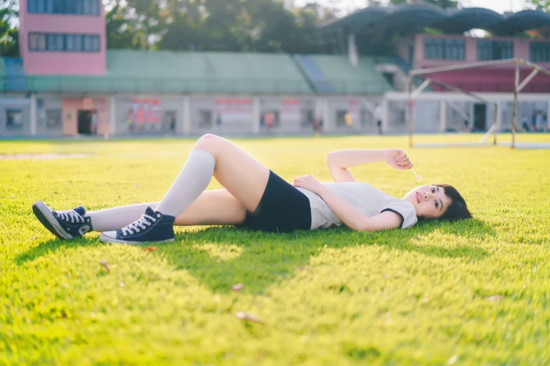 a woman lays on the grass with her feet on a flying disk