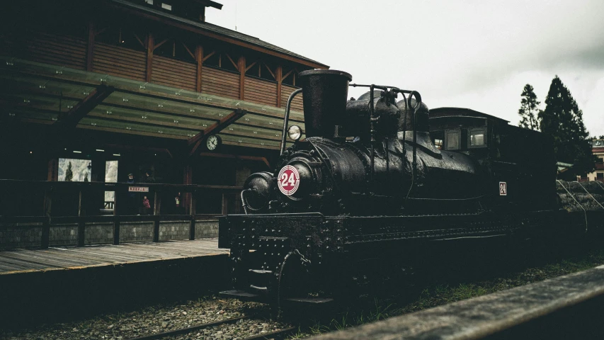 a large train on a steel track near a building