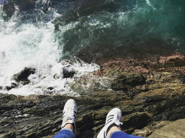 feet on a rock overlooking the ocean