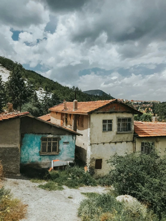 a picture of a house in the mountains with clouds above