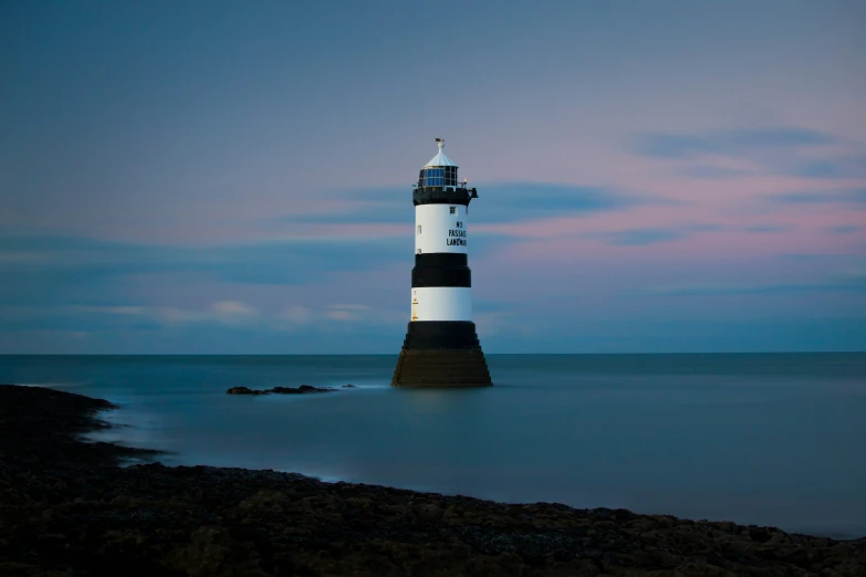 a light house stands in the middle of a body of water