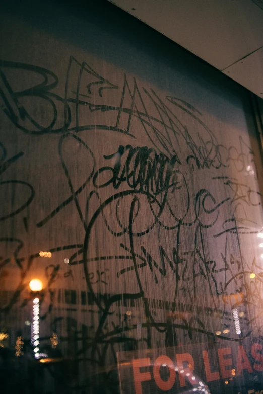 graffiti on a wall is seen through the window