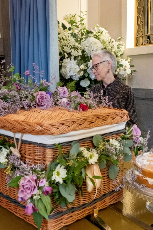 an older man sitting in front of a large cake and flower arrangement