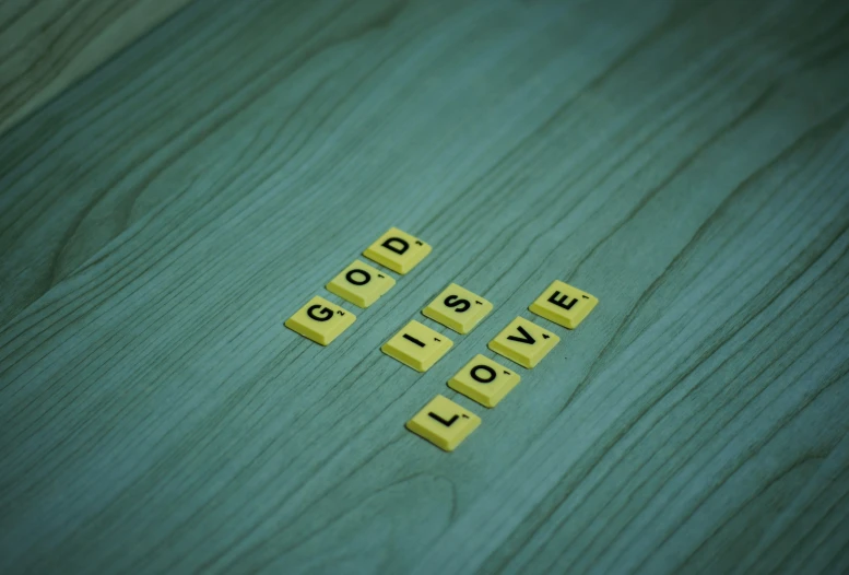 scrabble words that spell out the word love on a wooden table