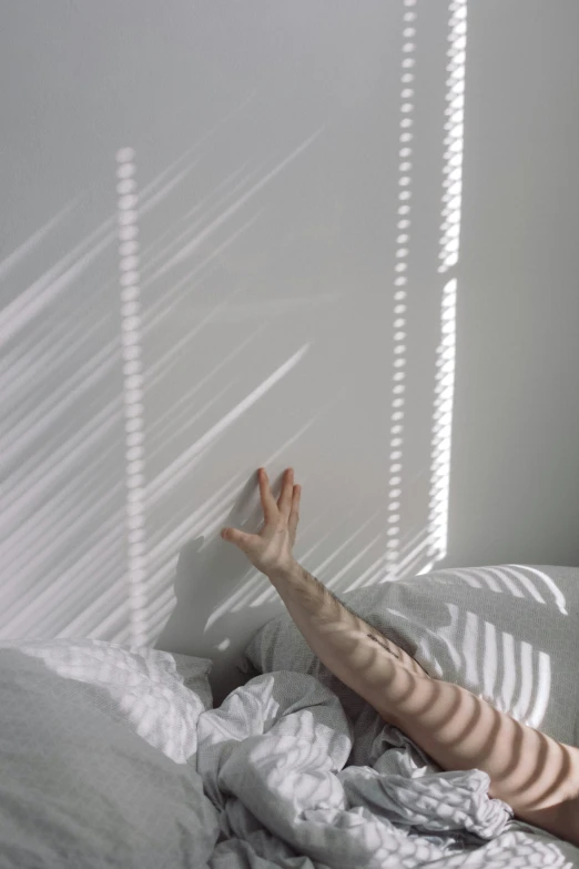 a woman laying in a bed in a white room