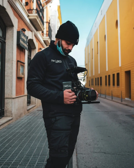 a man in winter gear with a camera on the street