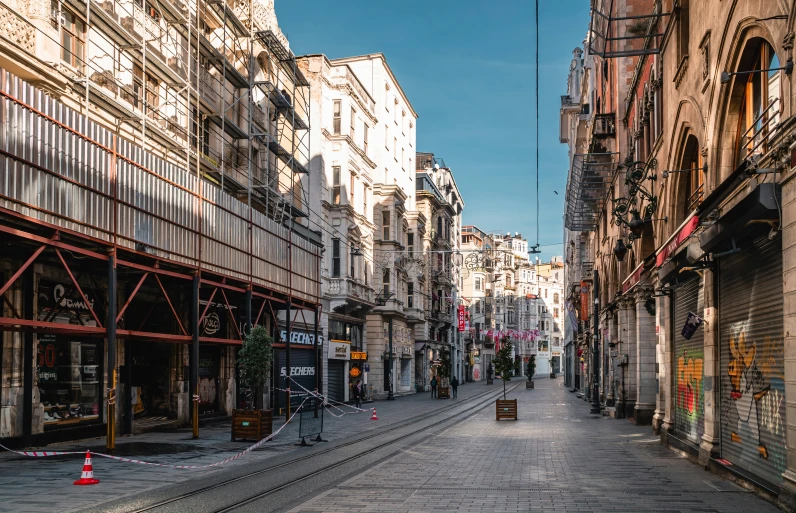 an empty city street with cars parked along side of buildings