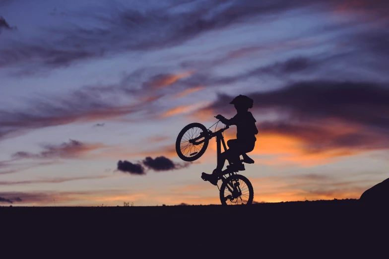 a man holding on to his bike as it sets off