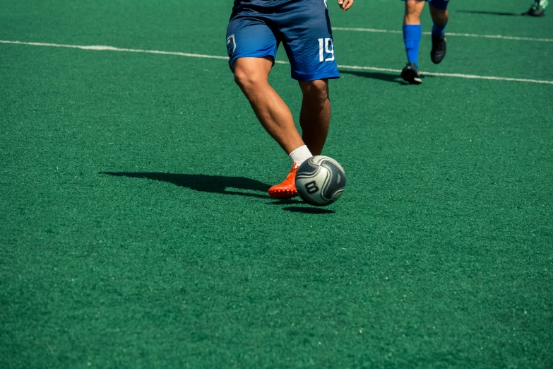 two young men kicking soccer balls around an open field