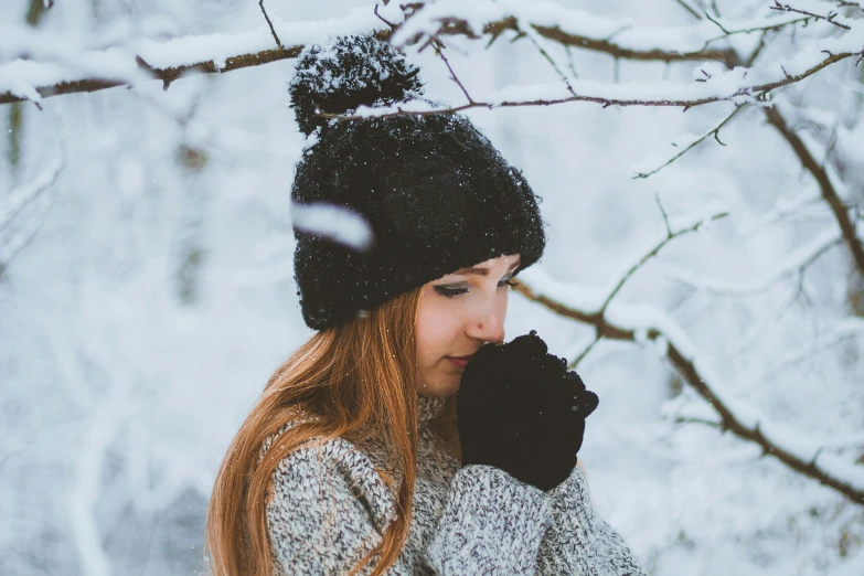 a girl wearing winter clothing and a black hat