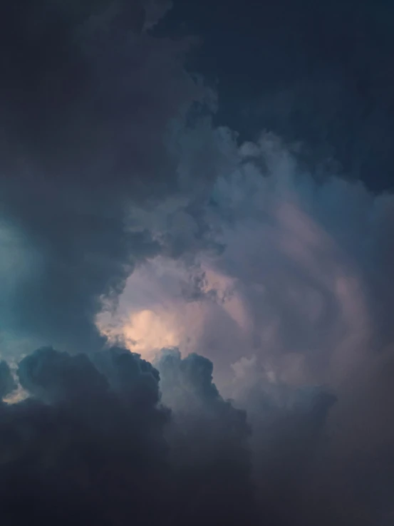 a very large cloud with an airplane in the sky