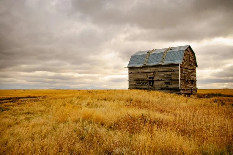 an old abandoned building is surrounded by tall grass