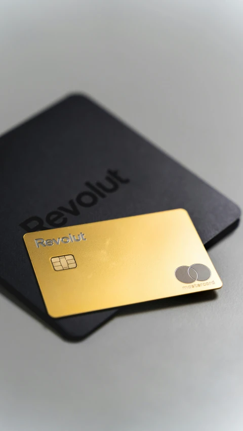 gold credit card resting on the same black credit card