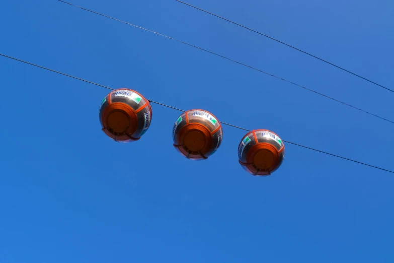 three round metal objects suspended by wires and wires