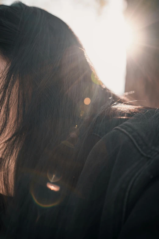 the woman is looking at her phone while sunlight shines down on her