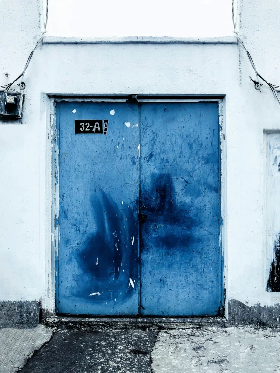 a blue door sitting between two white building