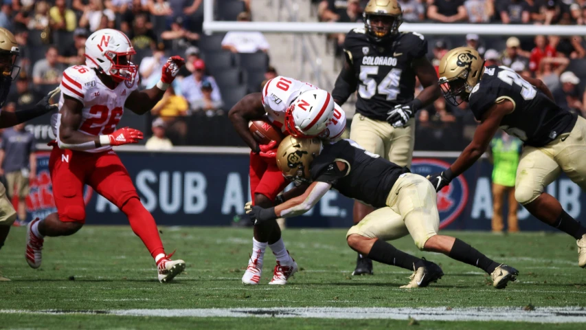 several players in uniforms running and playing football