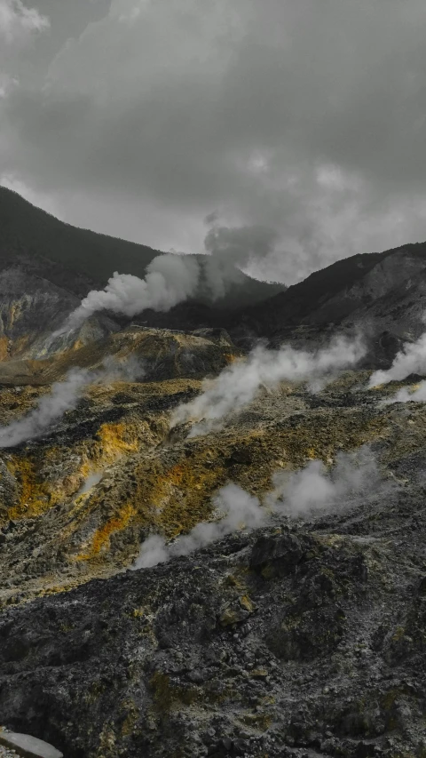 there are many hills with clouds moving from them