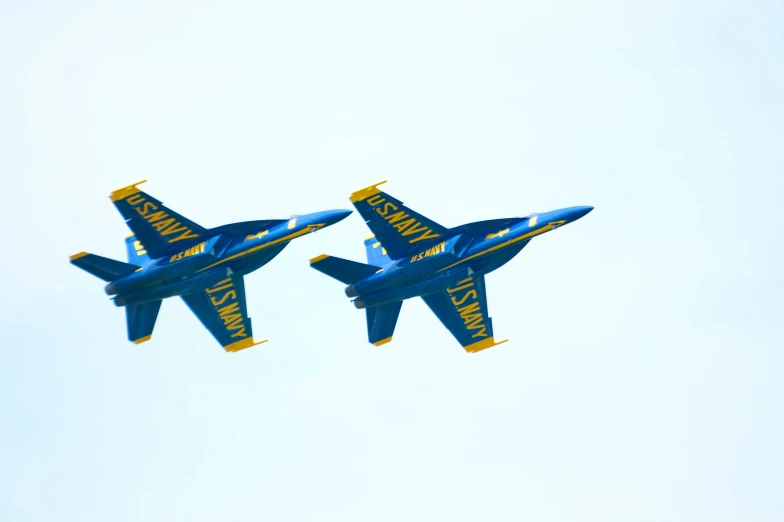 two blue angels jets flying in the sky