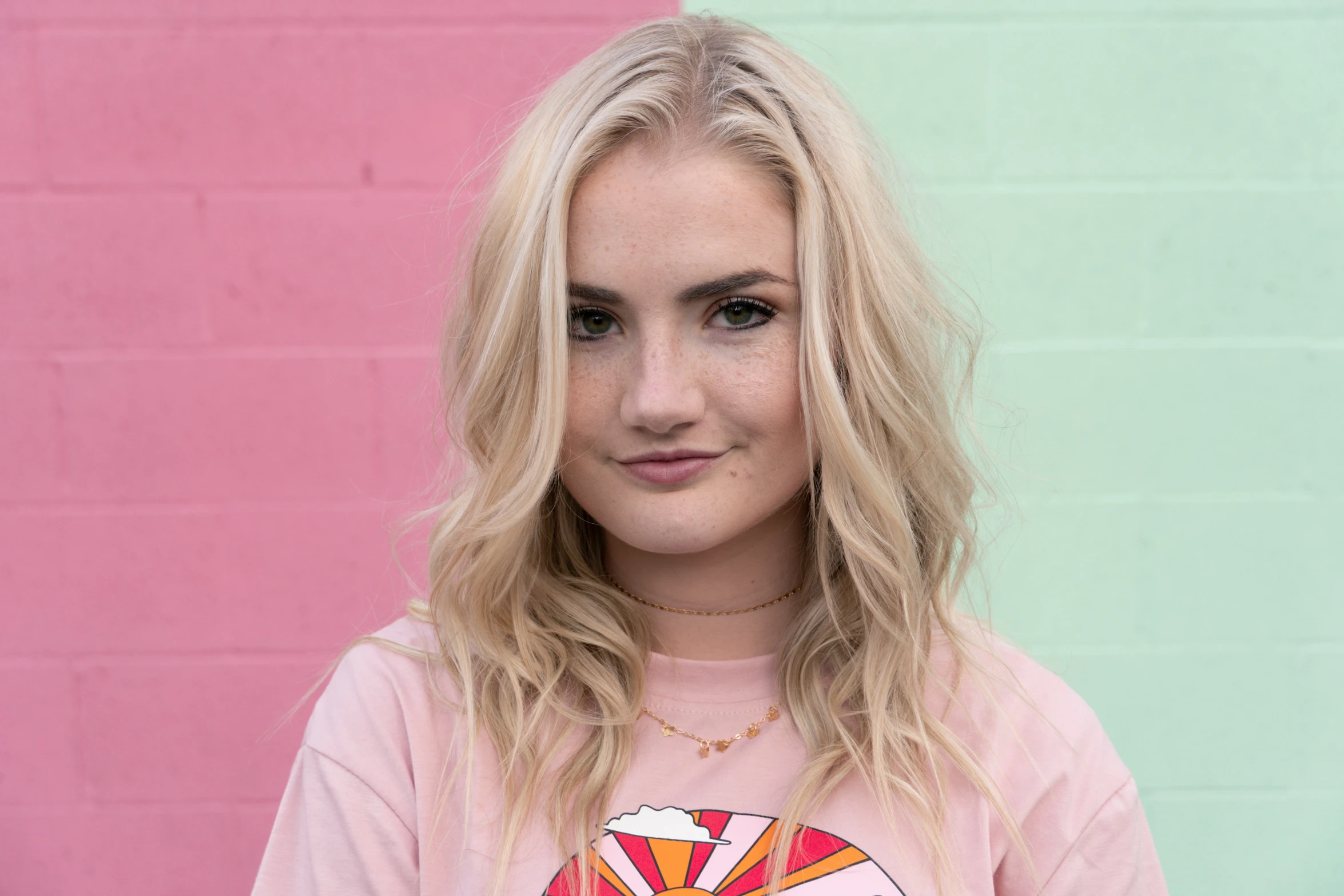 a woman in pink t shirt with a pink and blue wall