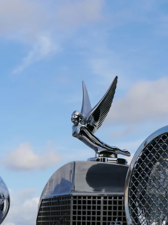 the chromed front grille and wing of an old car