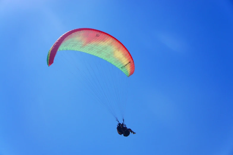 a para sails over the ocean under a blue sky