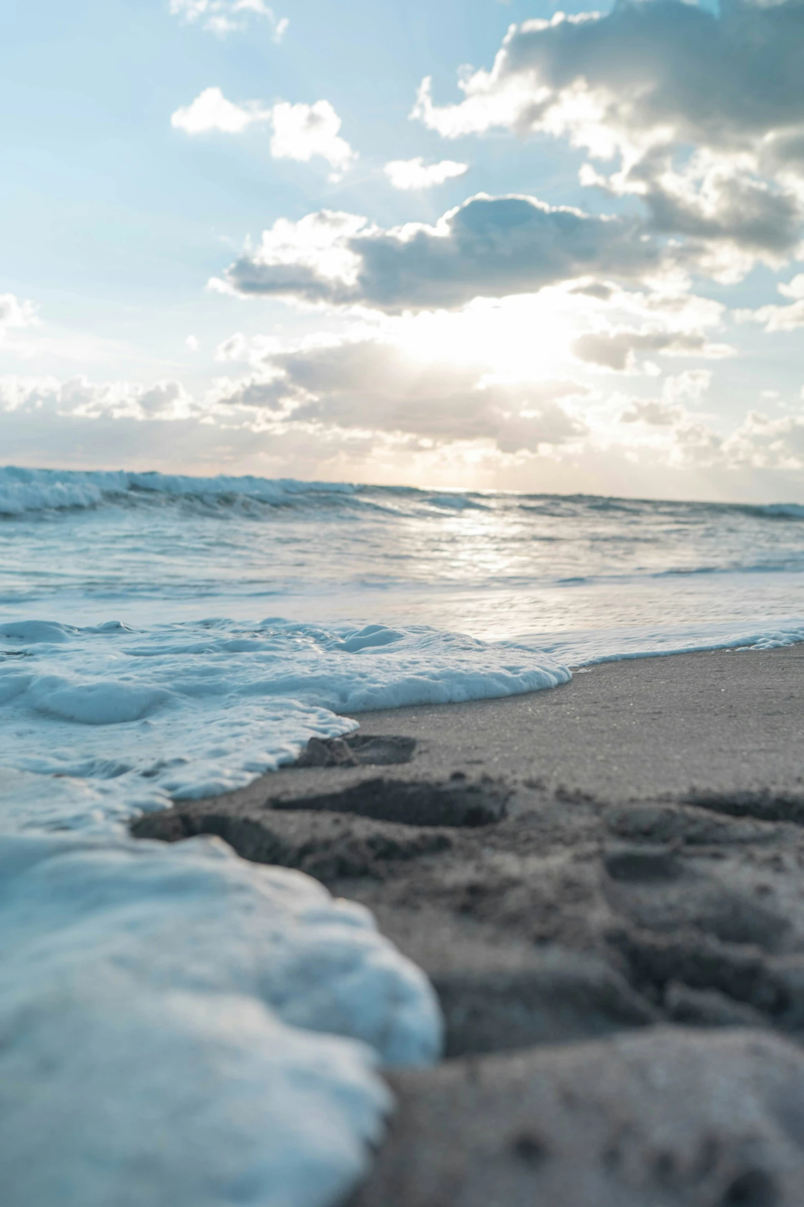 an ocean beach with small waves and sky