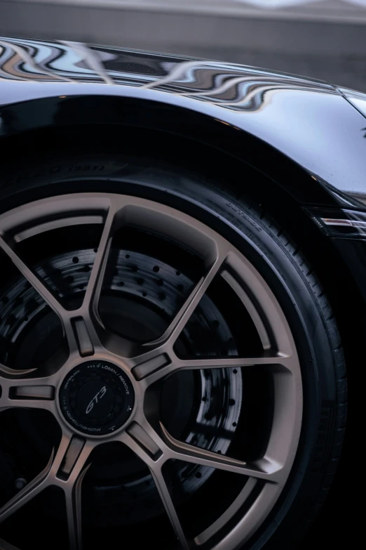 a very shiny car wheel with some black and grey accents