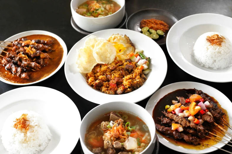 a table filled with bowls and dishes full of food