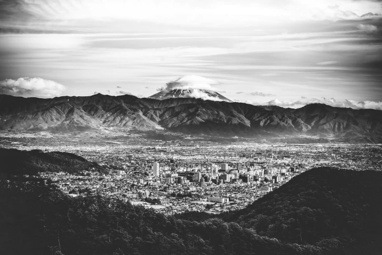 a black and white pograph of the mountains around a city