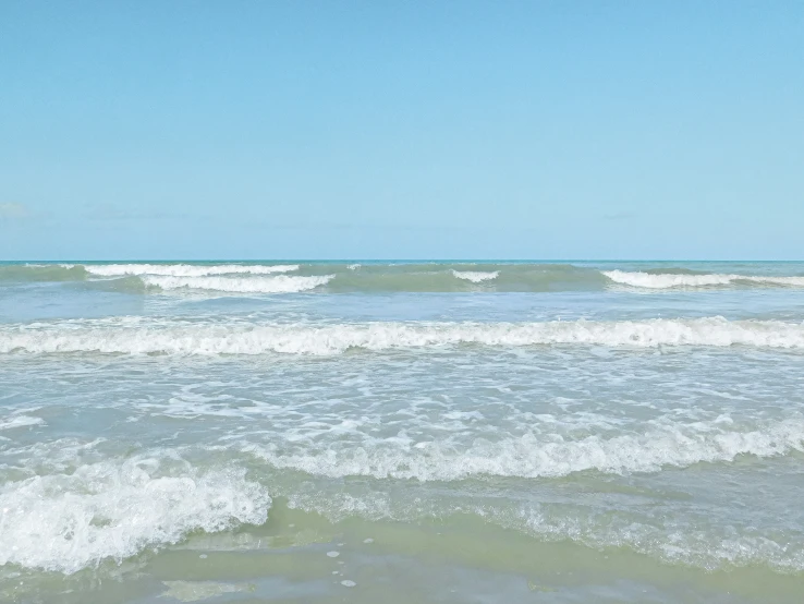 an ocean view of the water with crashing waves