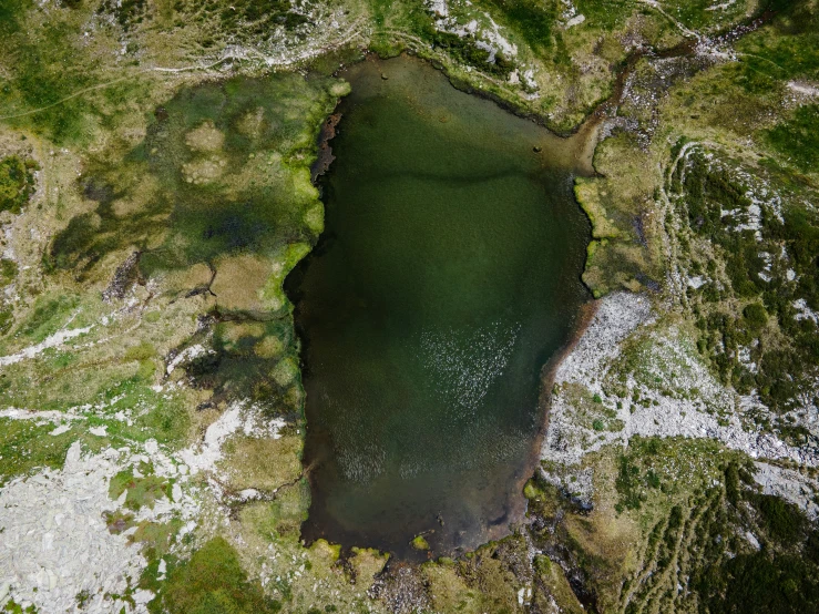 aerial view of a mountain lake surrounded by grass and rock