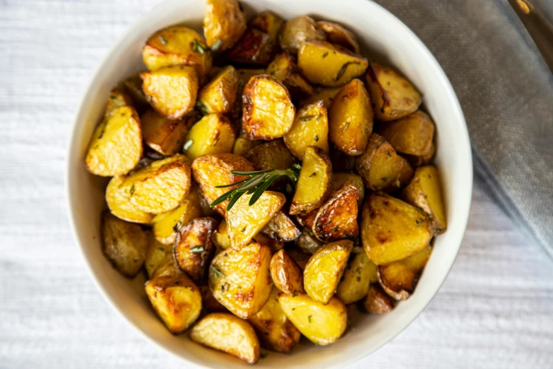 a bowl filled with roasted potatoes covered in sauce