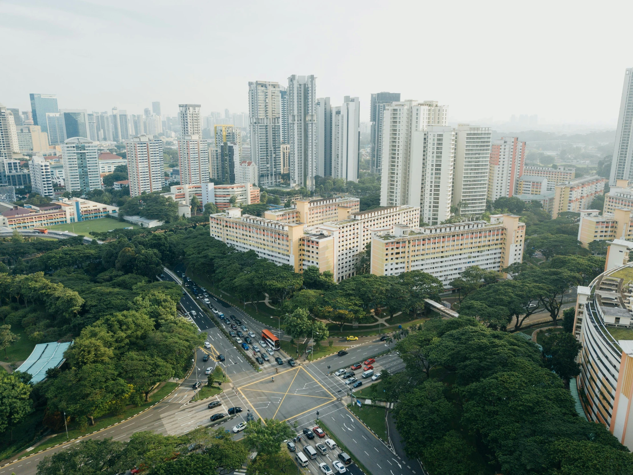 an aerial view of cityscape with trees and cars on road