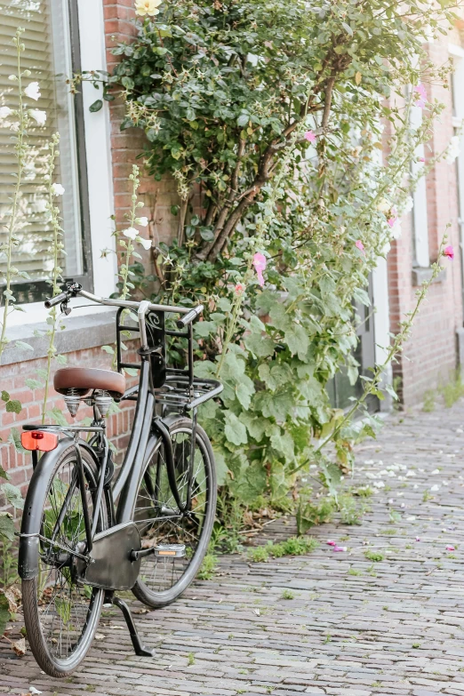 an old bike is parked next to a flower covered house