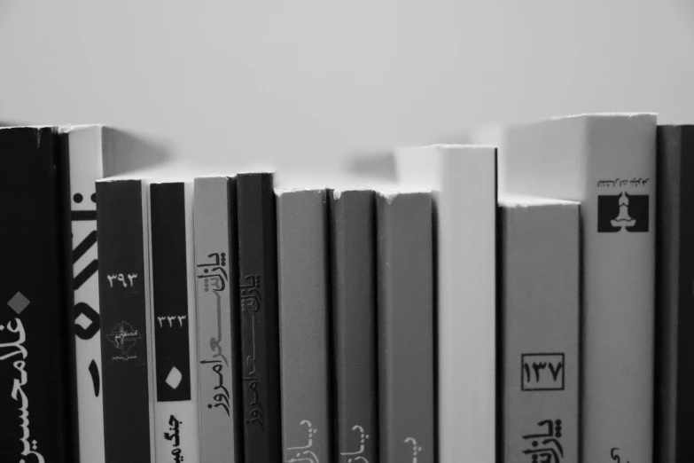 several black and white books on a white shelf