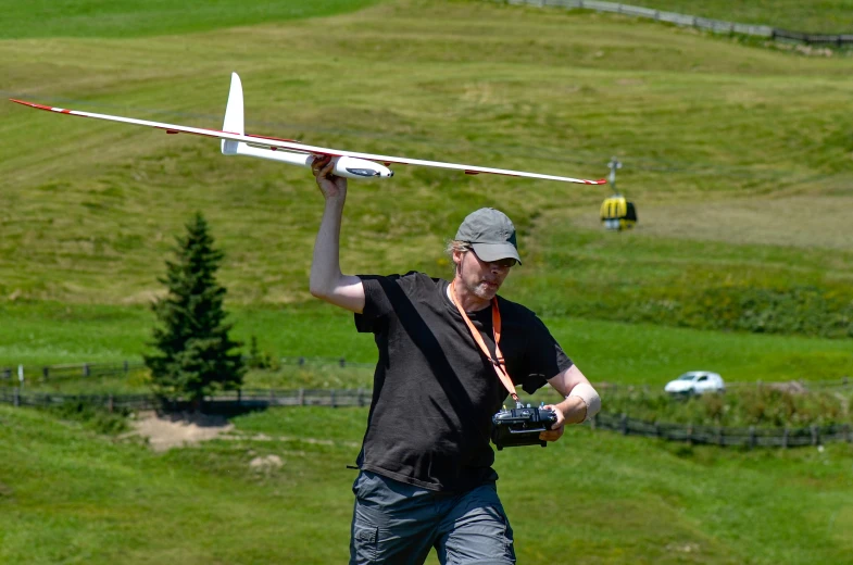 a man holding a glider over his head
