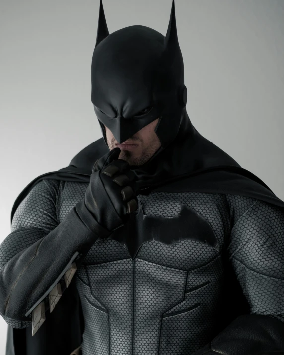 a man in a batman costume poses for the camera