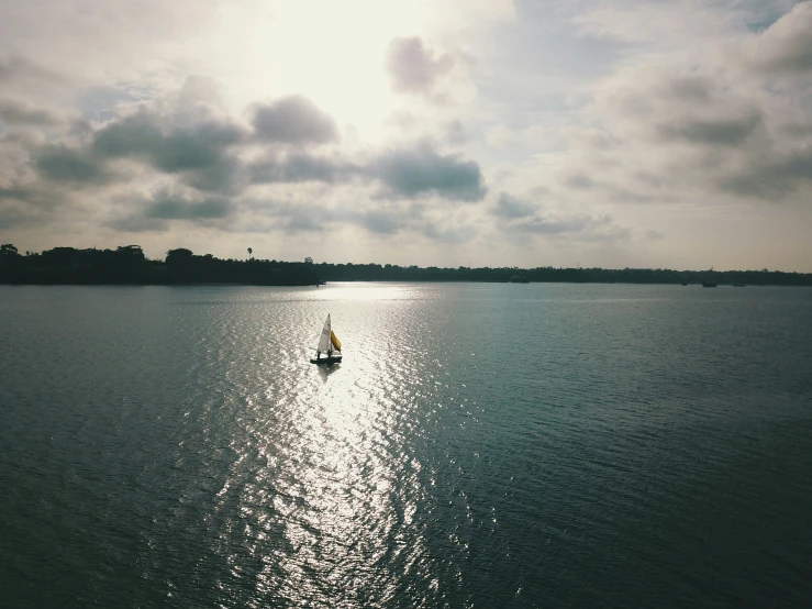 a sail boat floating in the water on a sunny day