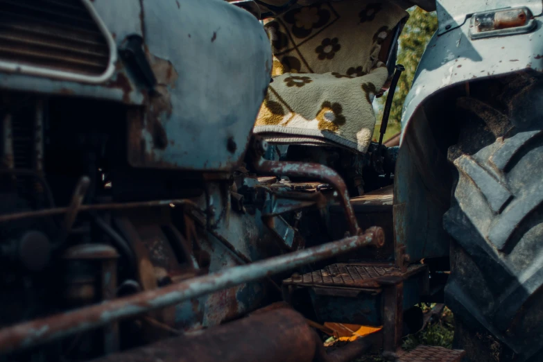 there is a large blue old car that is left to rust