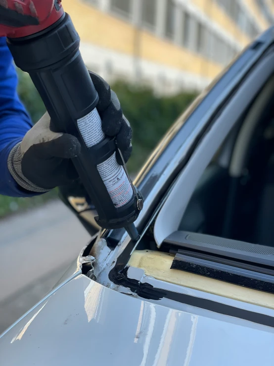 a person using a car window glass machine to repair the windshield