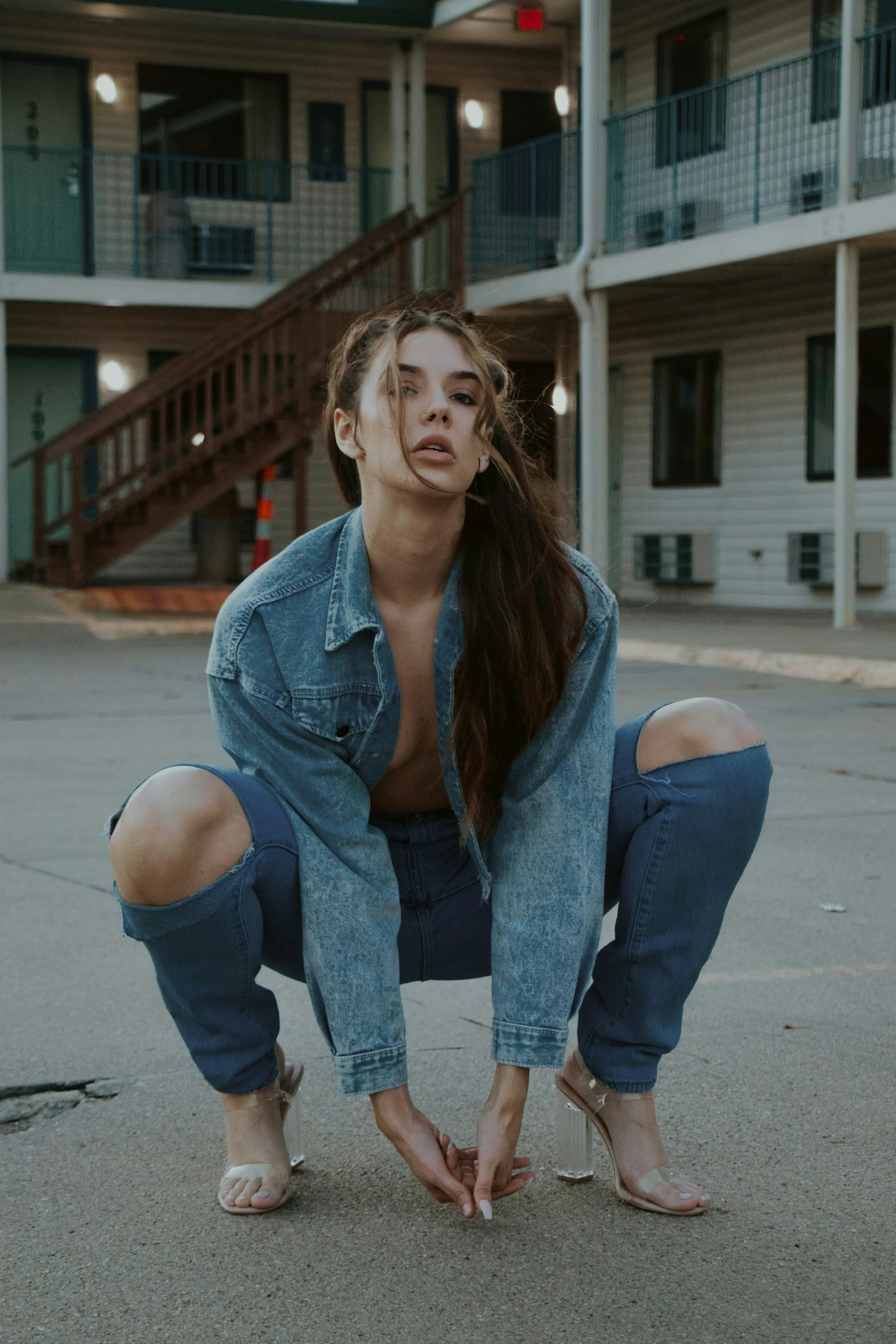 a woman crouched down on the ground and posing for a picture