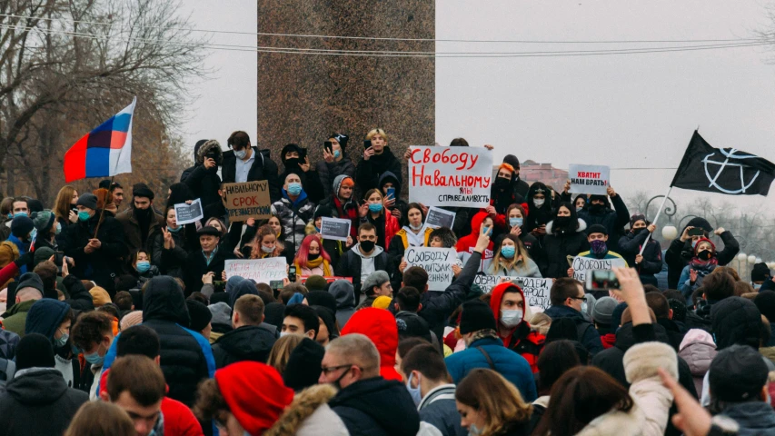 a group of people walking on a sidewalk with protest signs